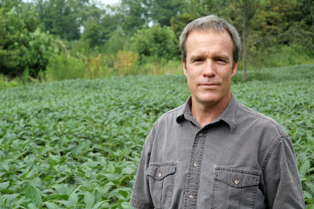 Professor Craig Harper stands in a food plot for deer.